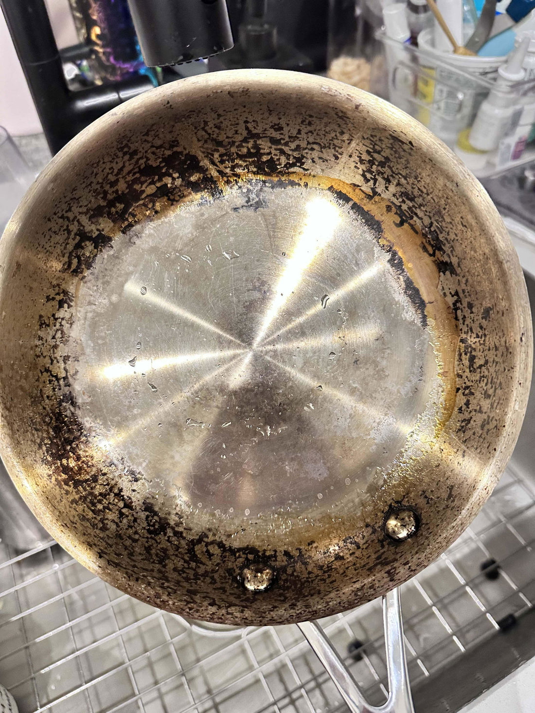Burnt-on carbon coating a customer’s stainless steel pan before using Steelé